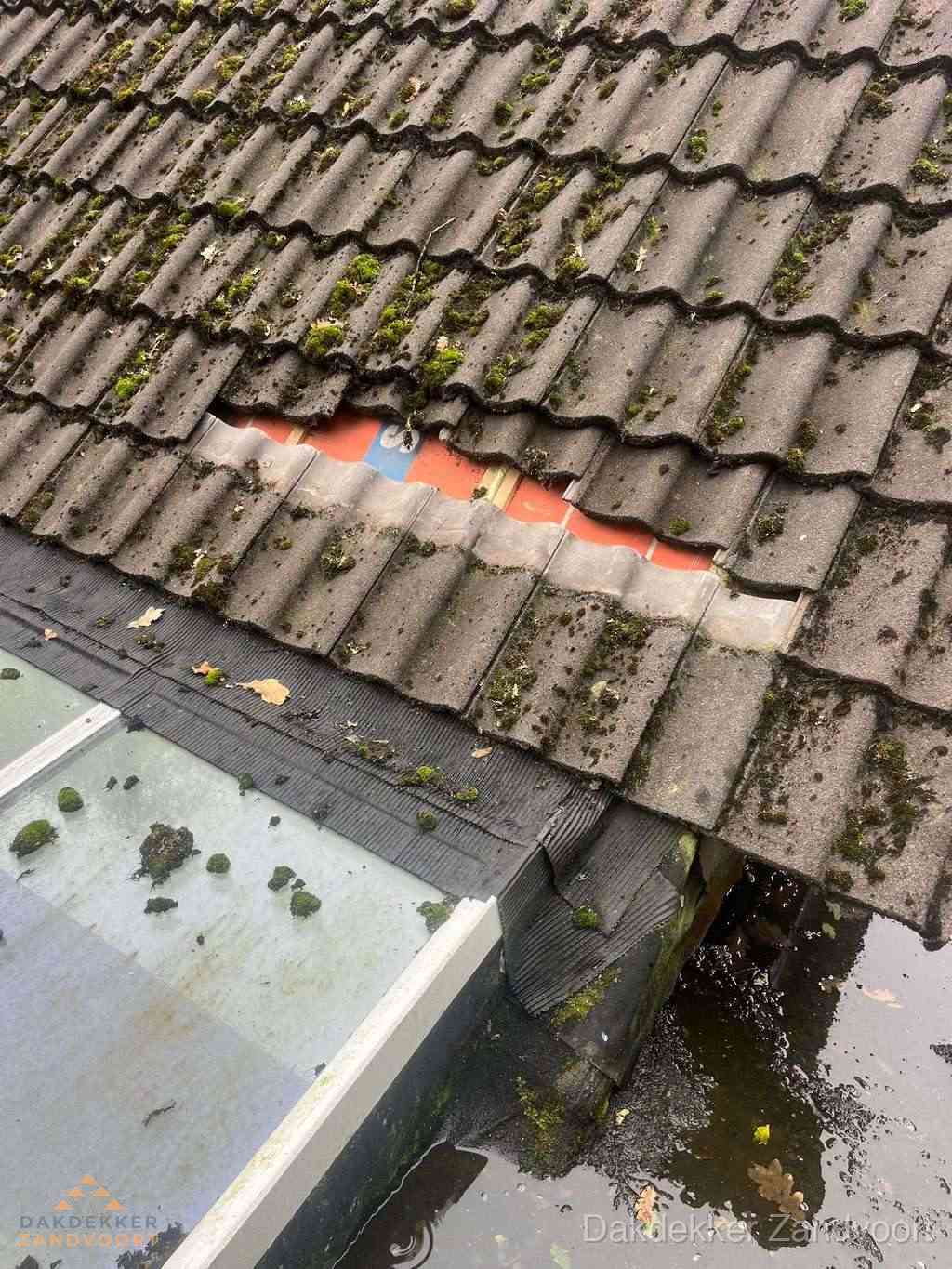 Beschadigd pannendak met ontbrekende dakpannen voor reparatie in Zandvoort