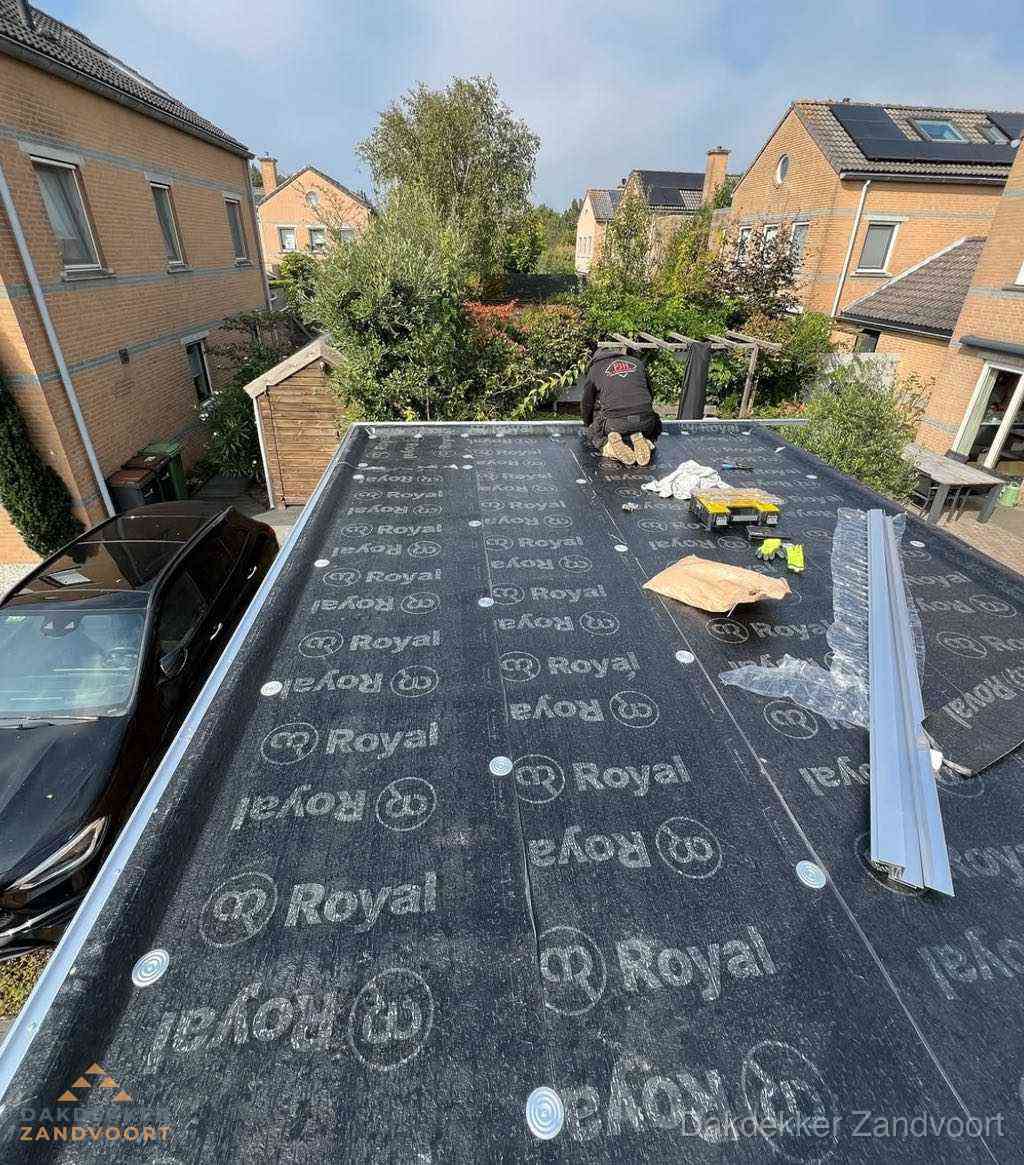 Dakdekker aan het werk op plat dak renovatie in Zandvoort