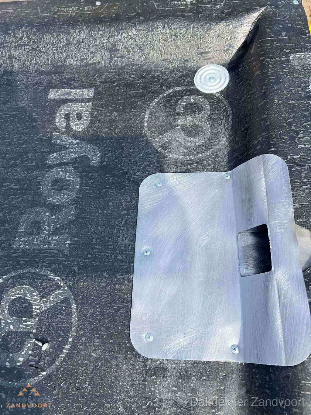 Dakdoorvoer met metalen afvoerplaat op bitumen dak in Zandvoort