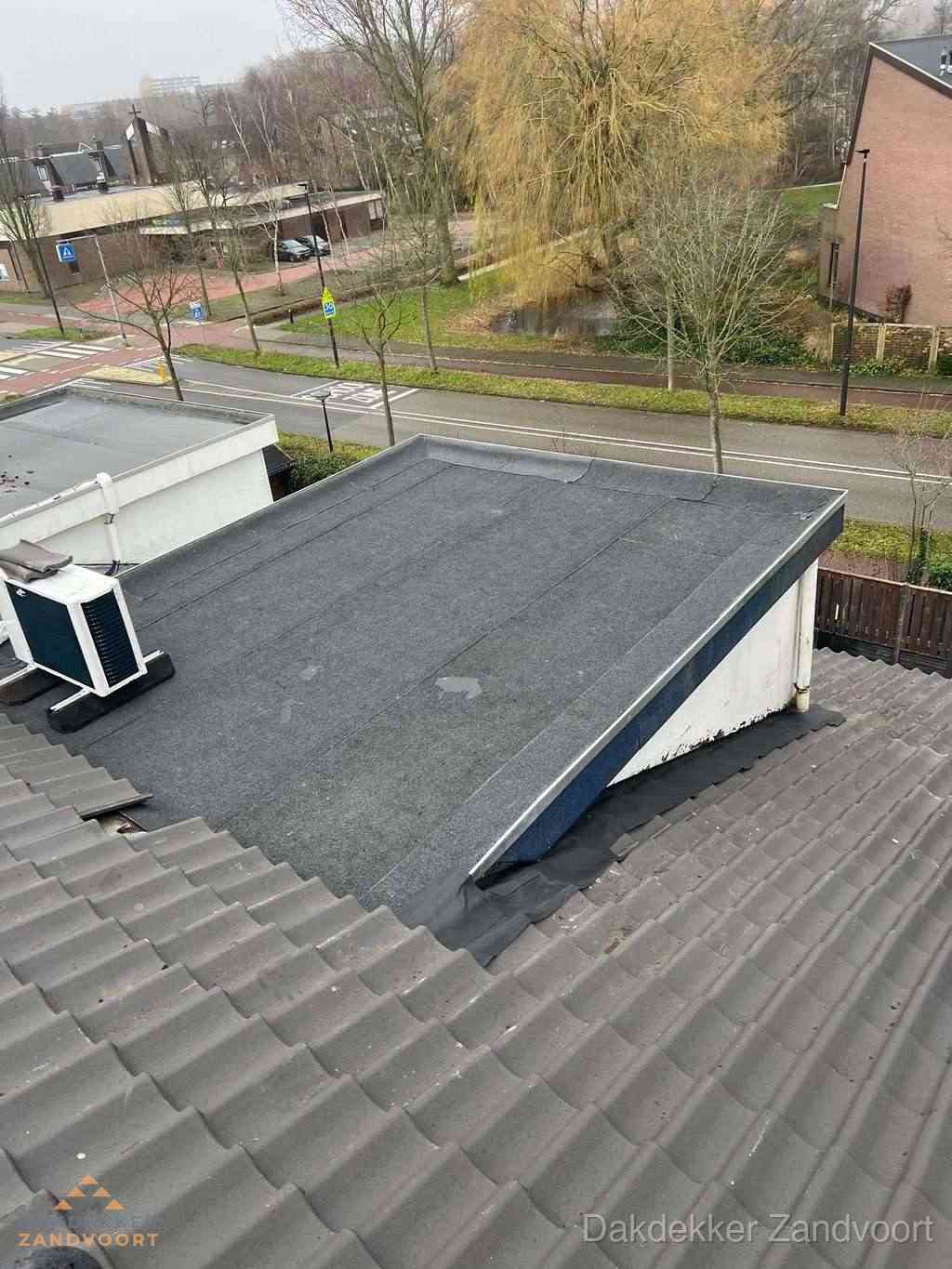Plat dak met bitumen dakbedekking naast schuin pannendak in Zandvoort