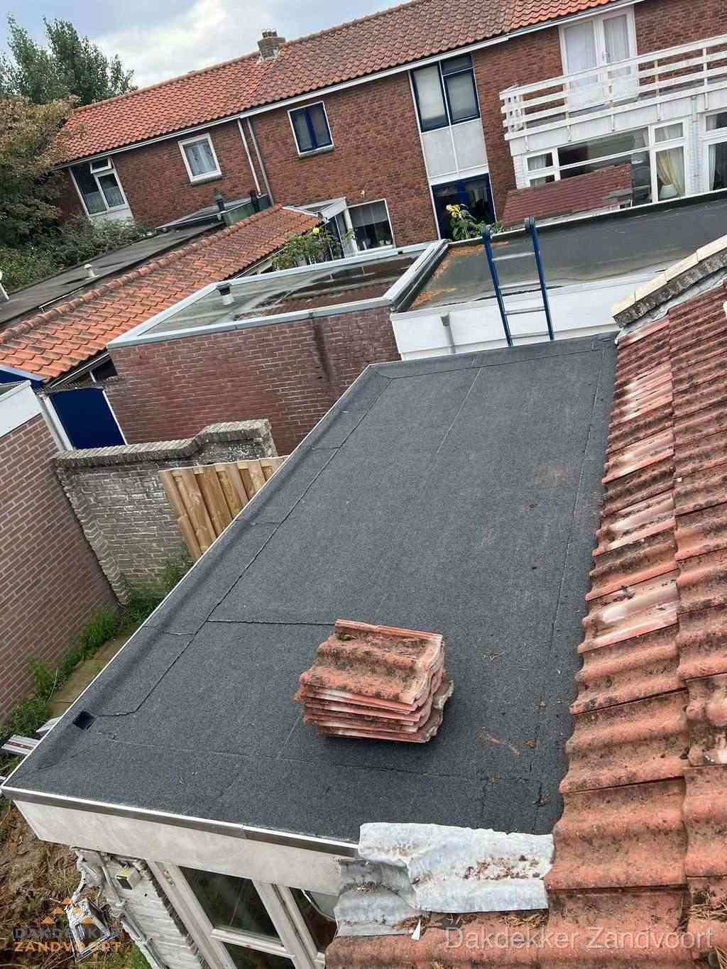 Aanbouw plat dak met reservepannen voor dakpannen vervangen in Zandvoort