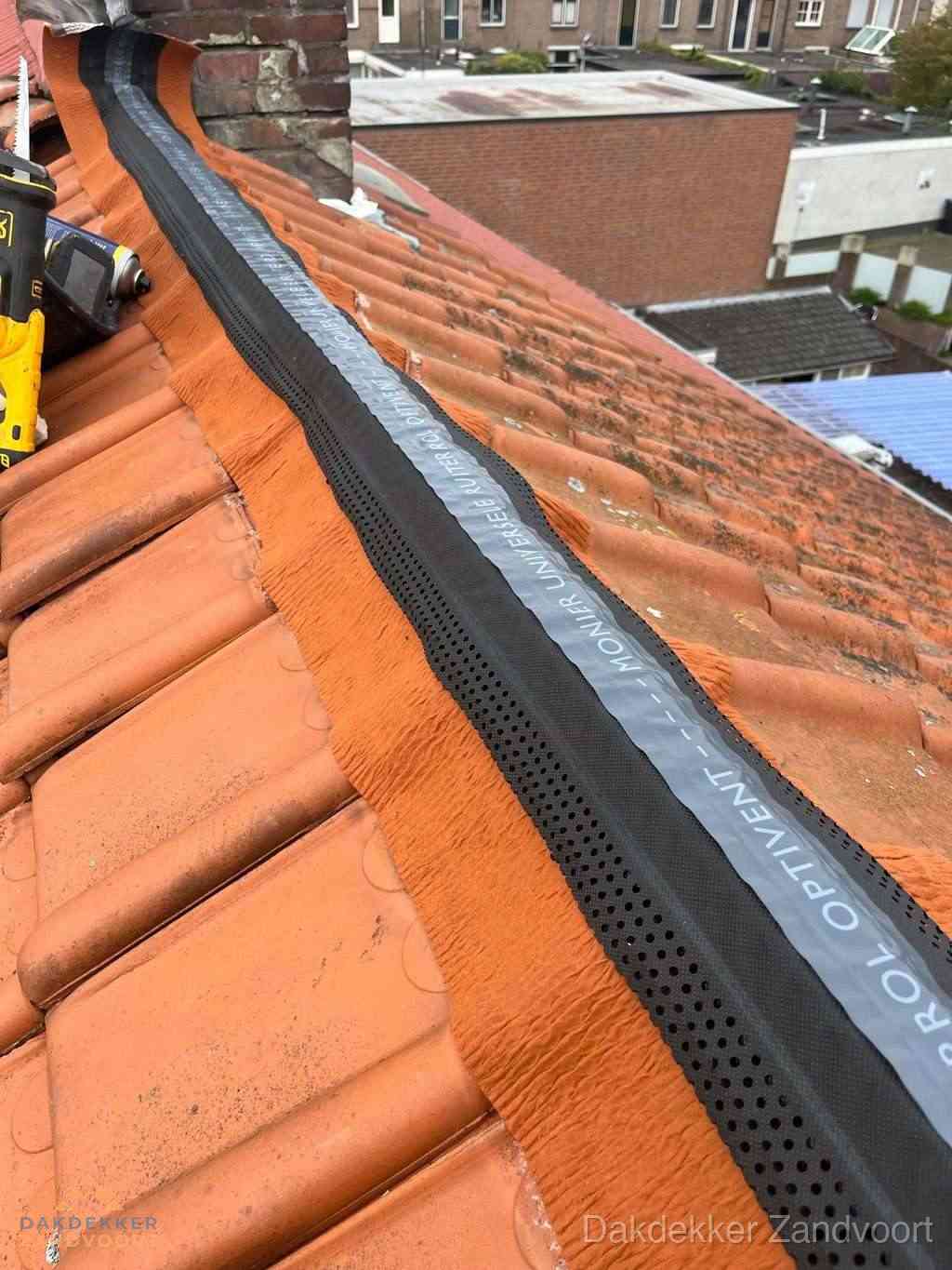 Plat dak aanbouw met bitumen naast schuin pannendak in Zandvoort